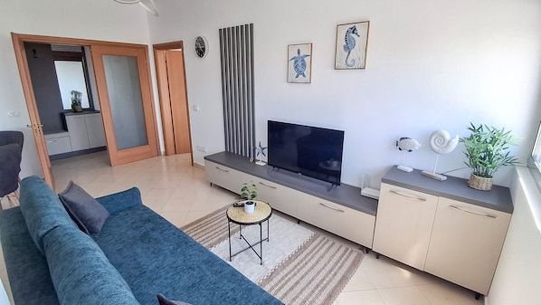Un salon moderne avec un canapé, un téléviseur et des objets de décoration.