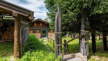 Eine rustikale Holzhütte mit einer Steinwand, einer Holztreppe und einem Holzzaun.
