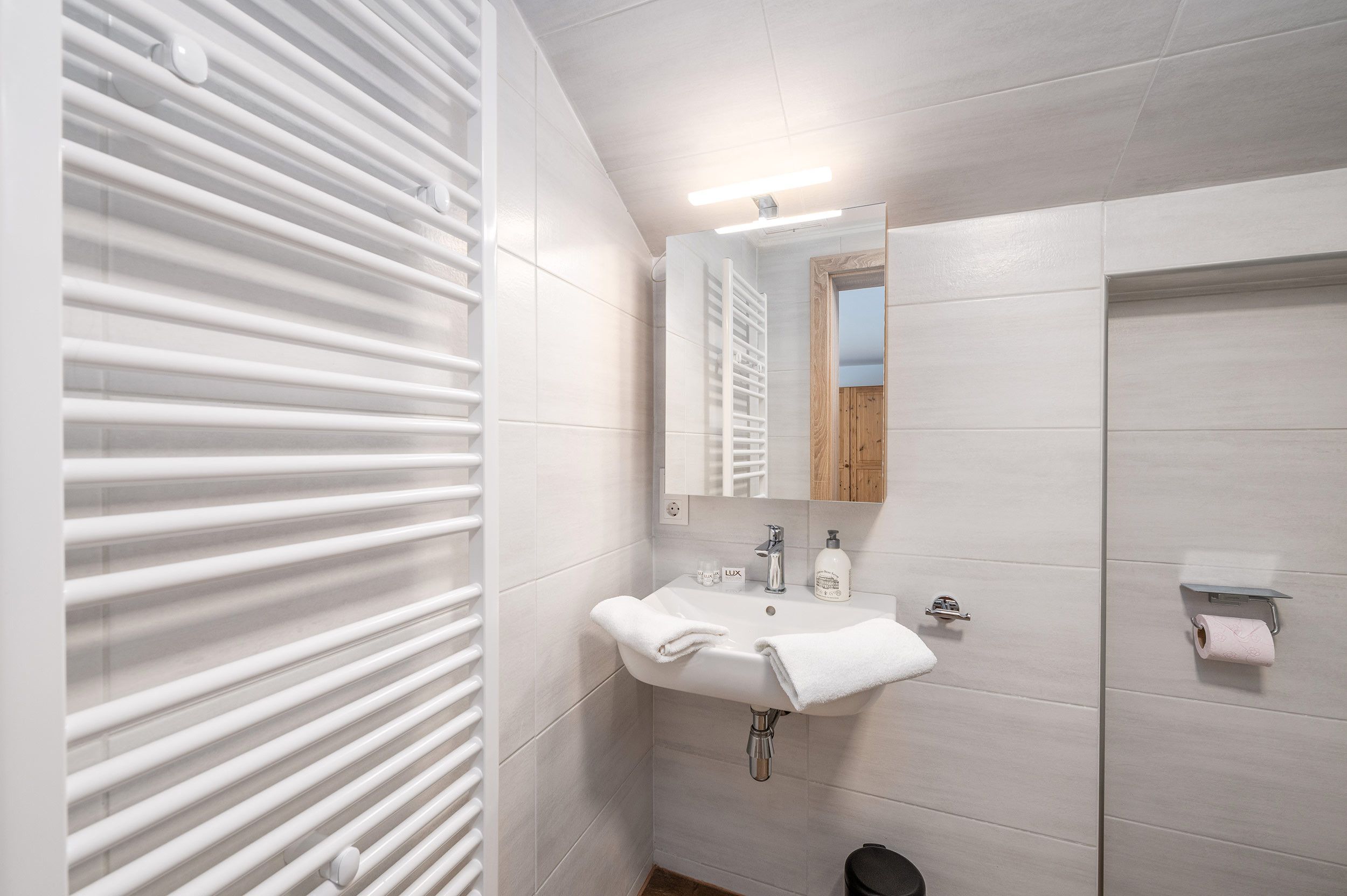 Ein modernes Badezimmer mit Waschbecken, Spiegel und Handtuchhalter.