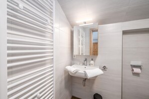 Ein modernes Badezimmer mit Waschbecken, Spiegel und Handtuchhalter.