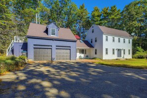 Ein zweistöckiges Haus mit Garage, überdachter Veranda und Satellitenschüssel.