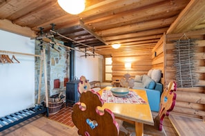 A cozy cabin interior with a wooden dining table, a sofa, and a stone wall. - Planai 66 - Bergstube (Schladming)