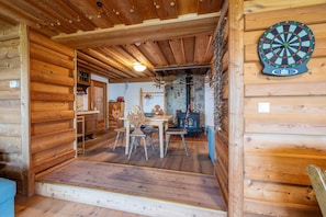 A wooden interior with a dartboard, a stone fireplace, and a dining area. - Planai 66 - Bergstube (Schladming)
