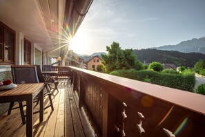 Un terrazzo in legno con vista sulle montagne e un cielo sereno.