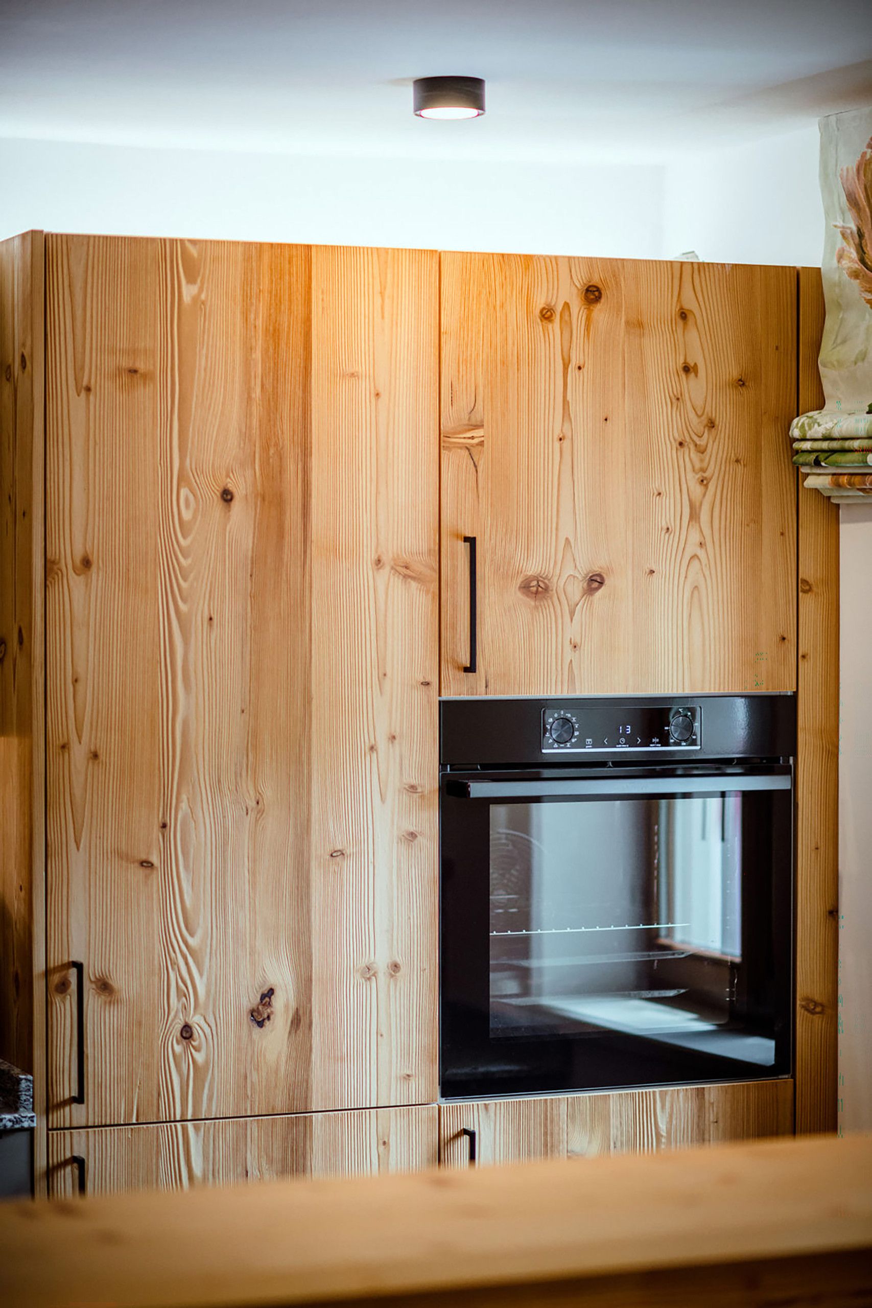Een keuken met houten kastjes en een inbouwoven.