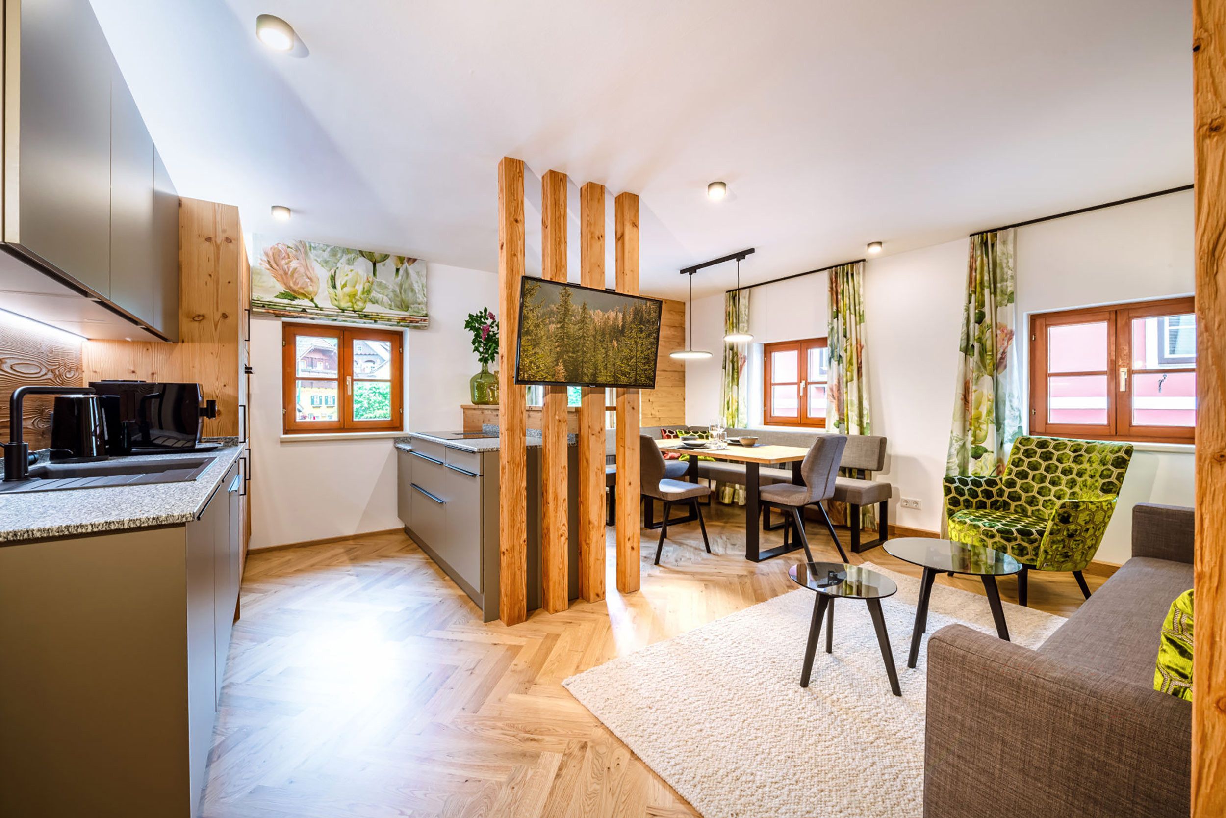 Una cucina moderna con zona pranzo, elementi in legno e televisore a schermo piatto.