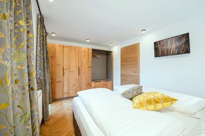 Una camera da letto con un letto, un armadio in legno, uno specchio e un quadro appeso al muro.