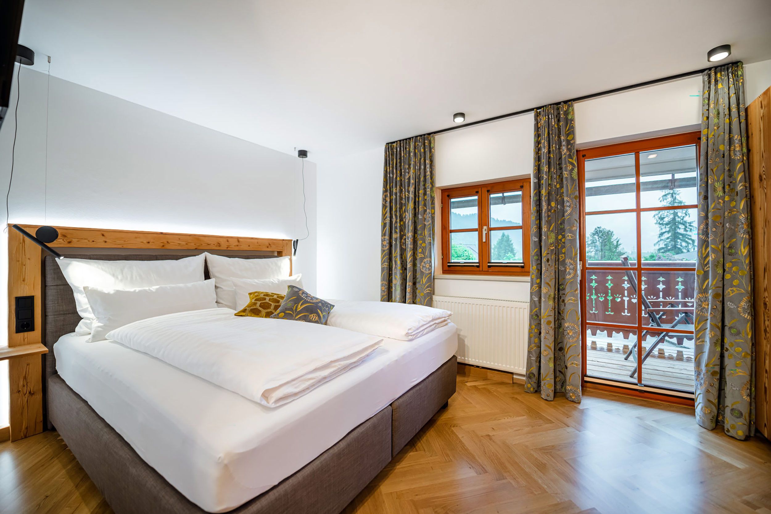 Una camera da letto con un letto in legno, una finestra con tende e vista sull'esterno.