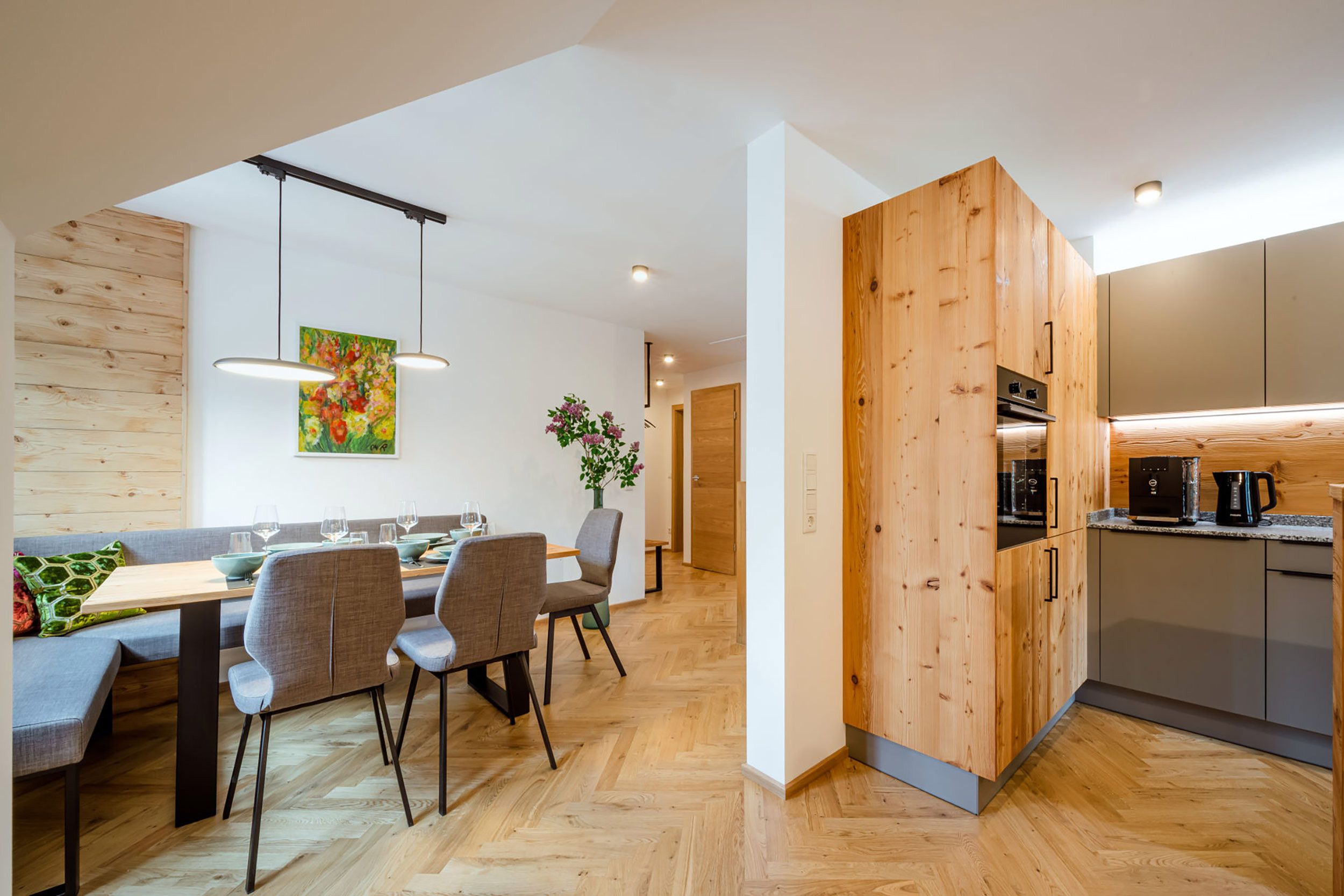 Una cucina moderna con mobili in legno e un'area pranzo con tavolo e sedie di legno.