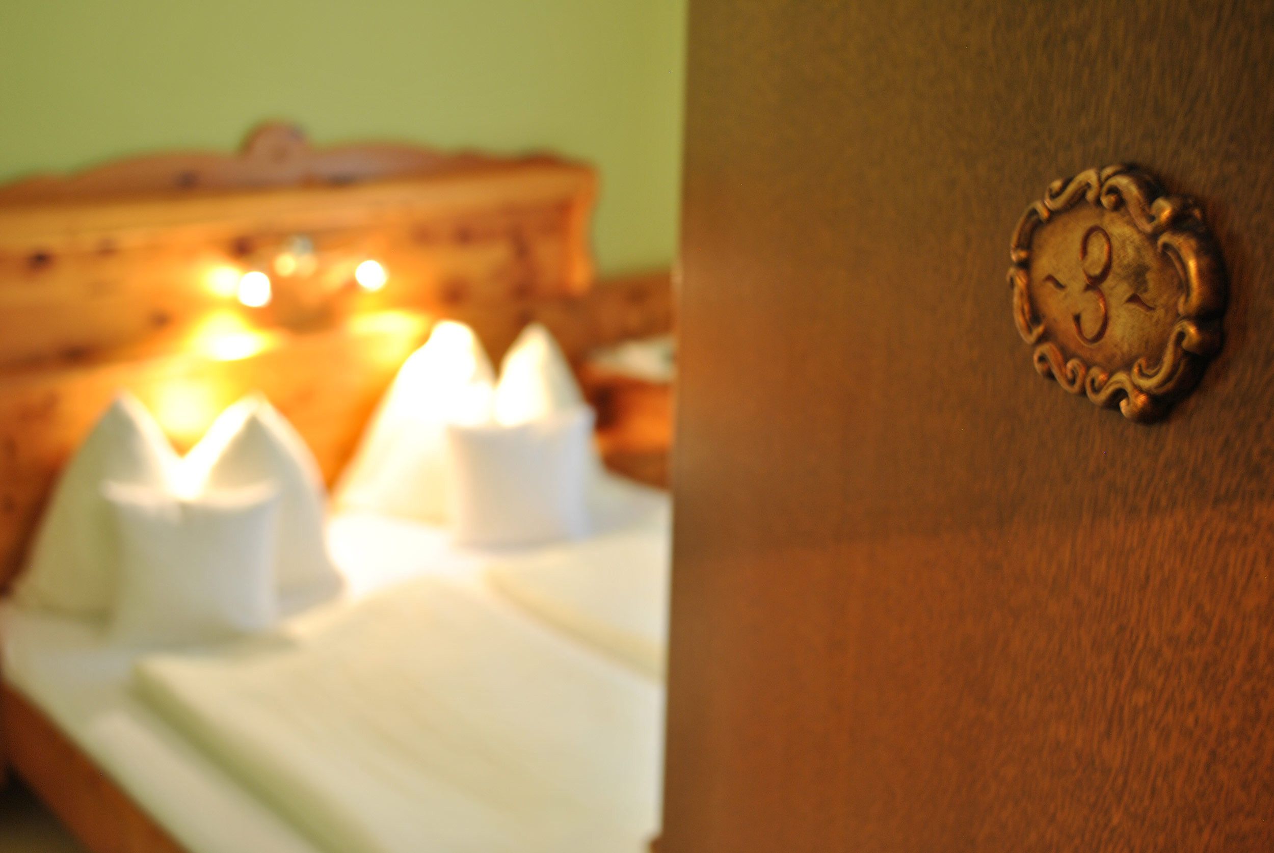 Ein Zimmer mit einem Bett, einem Holzkopfteil und einer Wandleuchte.