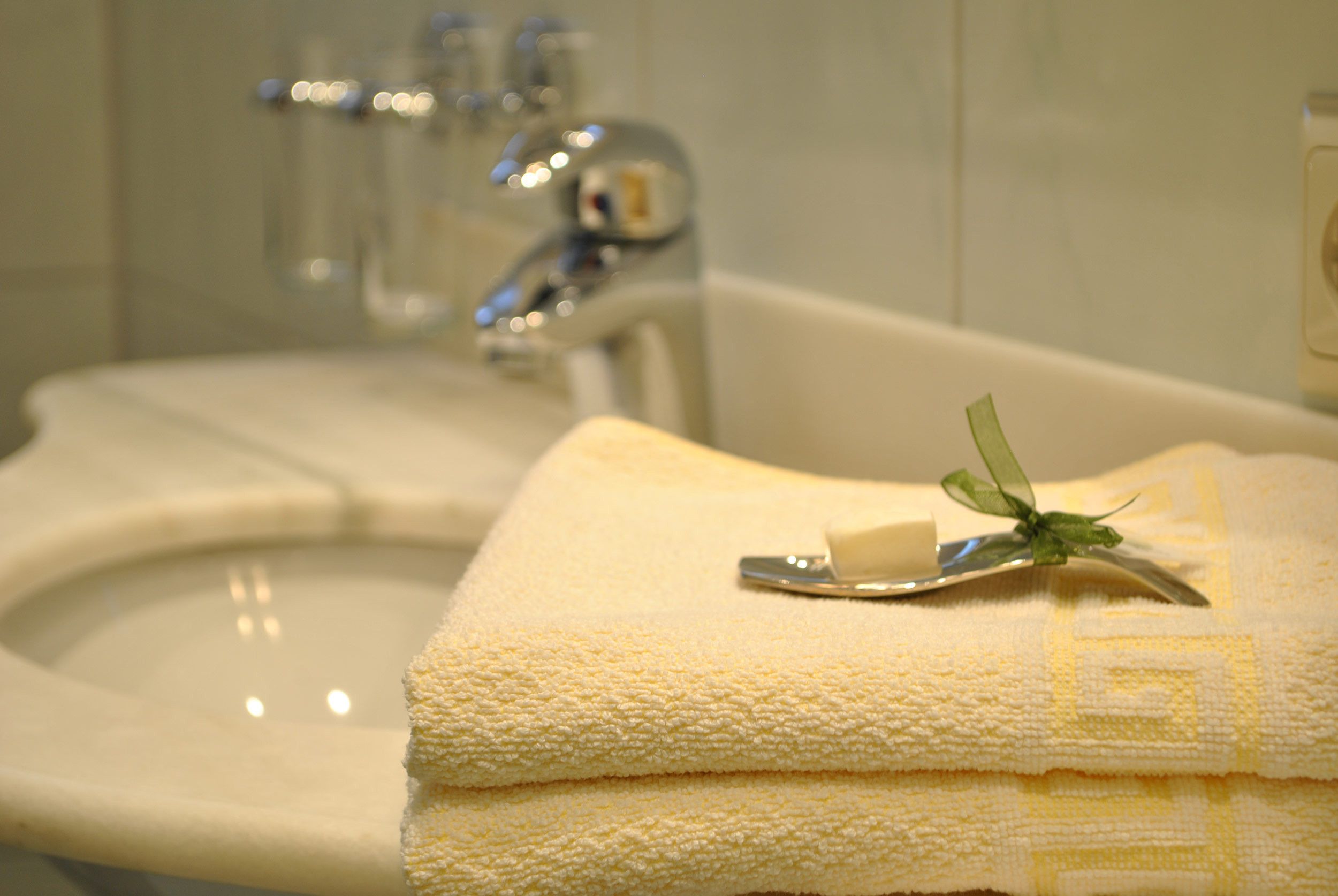 Un lavabo de salle de bain avec un miroir, une serviette et un porte-savon.