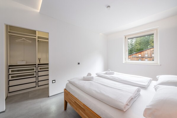 Un dormitorio con cama, ventana y vestidor.