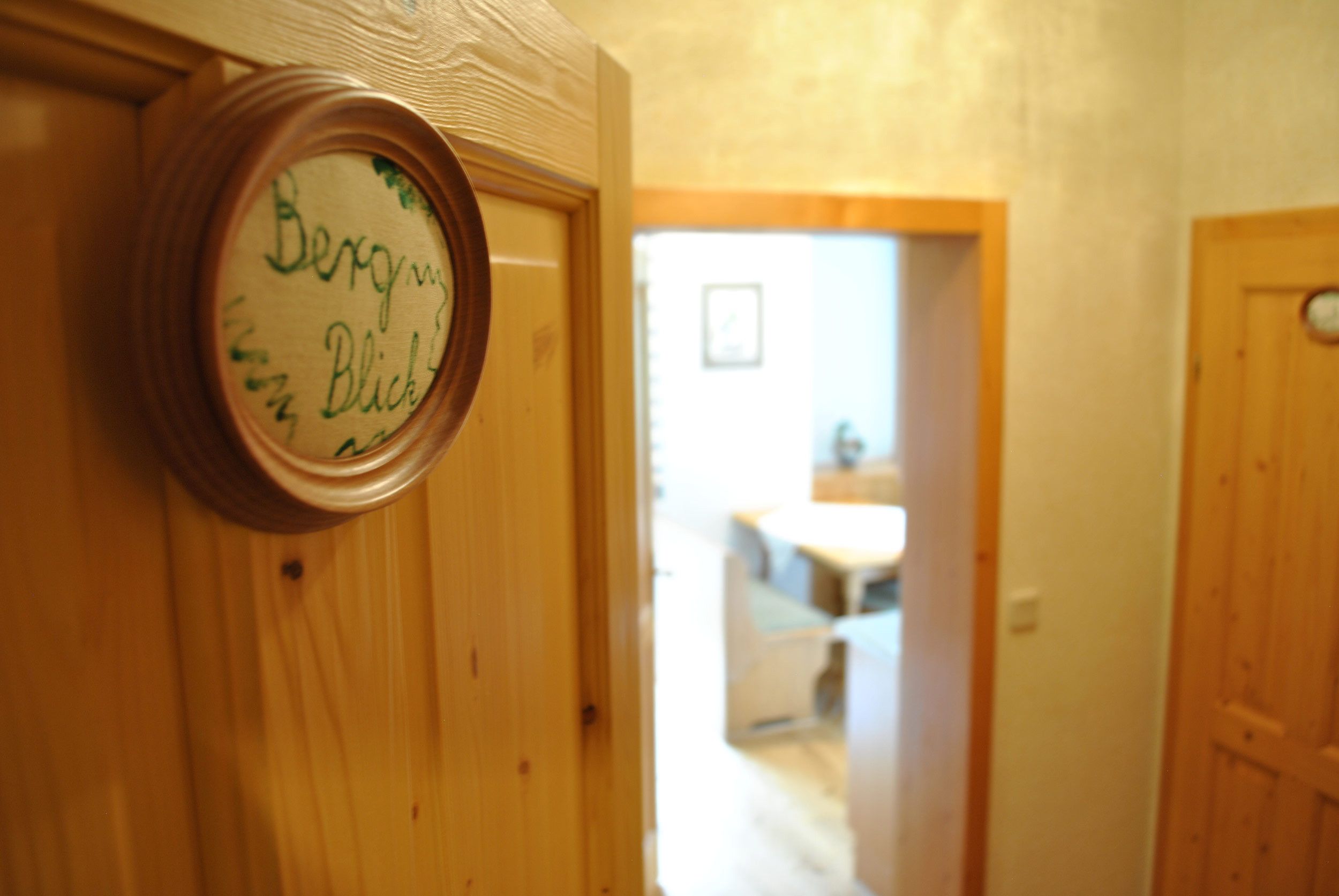 Ein Flur mit Holztüren und einem an der Wand befestigten Schild mit handgeschriebenem Text.