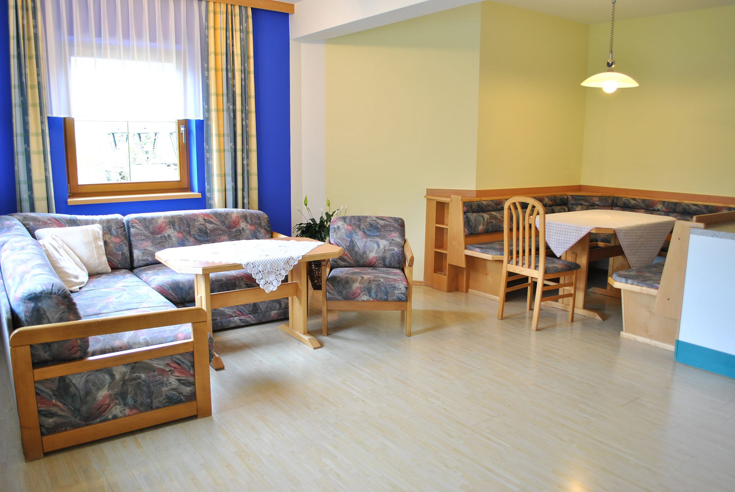Een kamer met een bank, een tafel en een lange stoel.