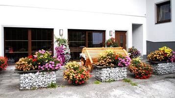 A building with multiple garage doors, a wooden bench, and flower planters.