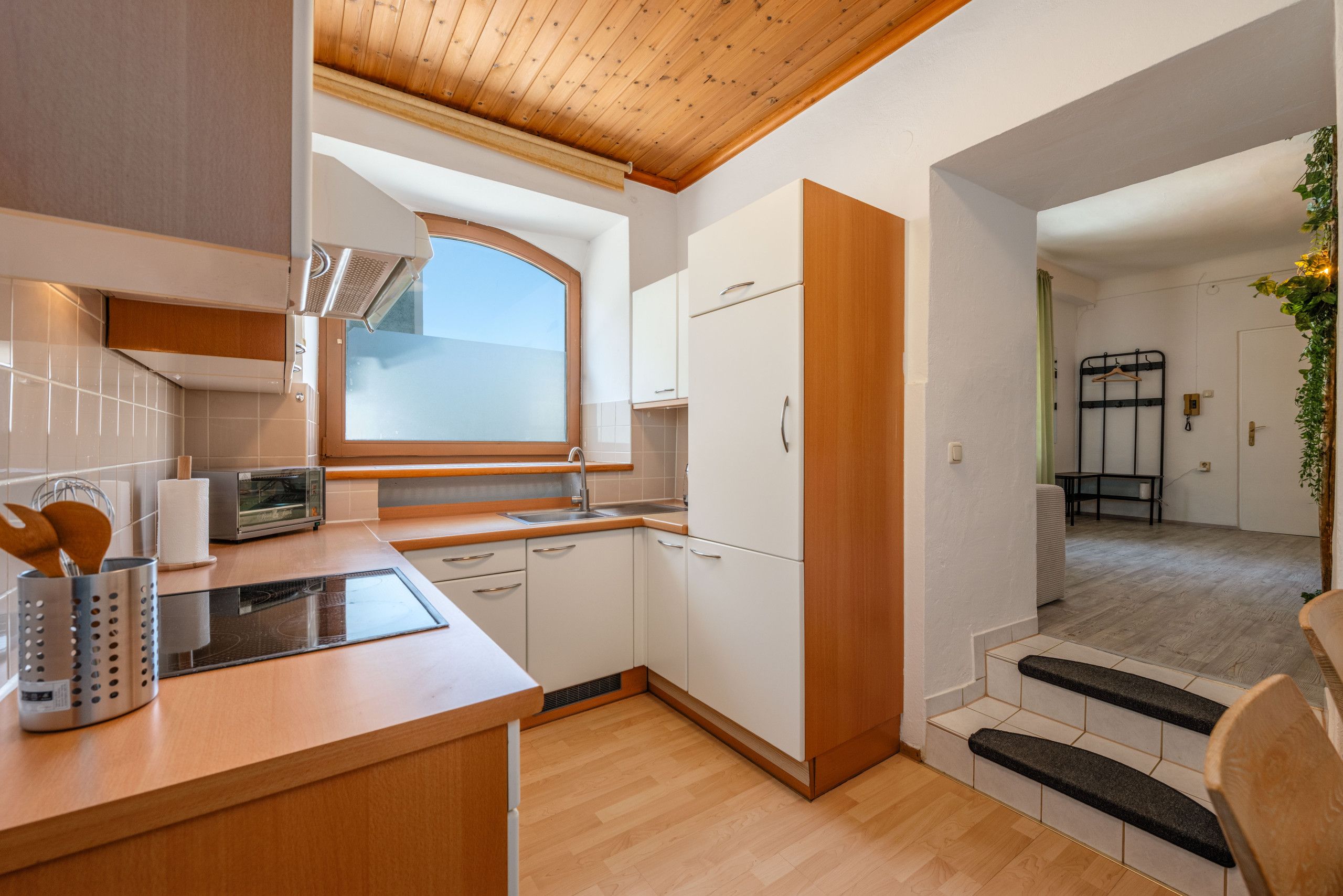 A compact kitchen with a built-in oven, a microwave, and a window above the sink.