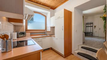 A compact kitchen with a built-in oven, a microwave, and a window above the sink.