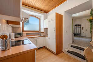 Una cucina compatta con forno a incasso, microonde e finestra sopra il lavello.