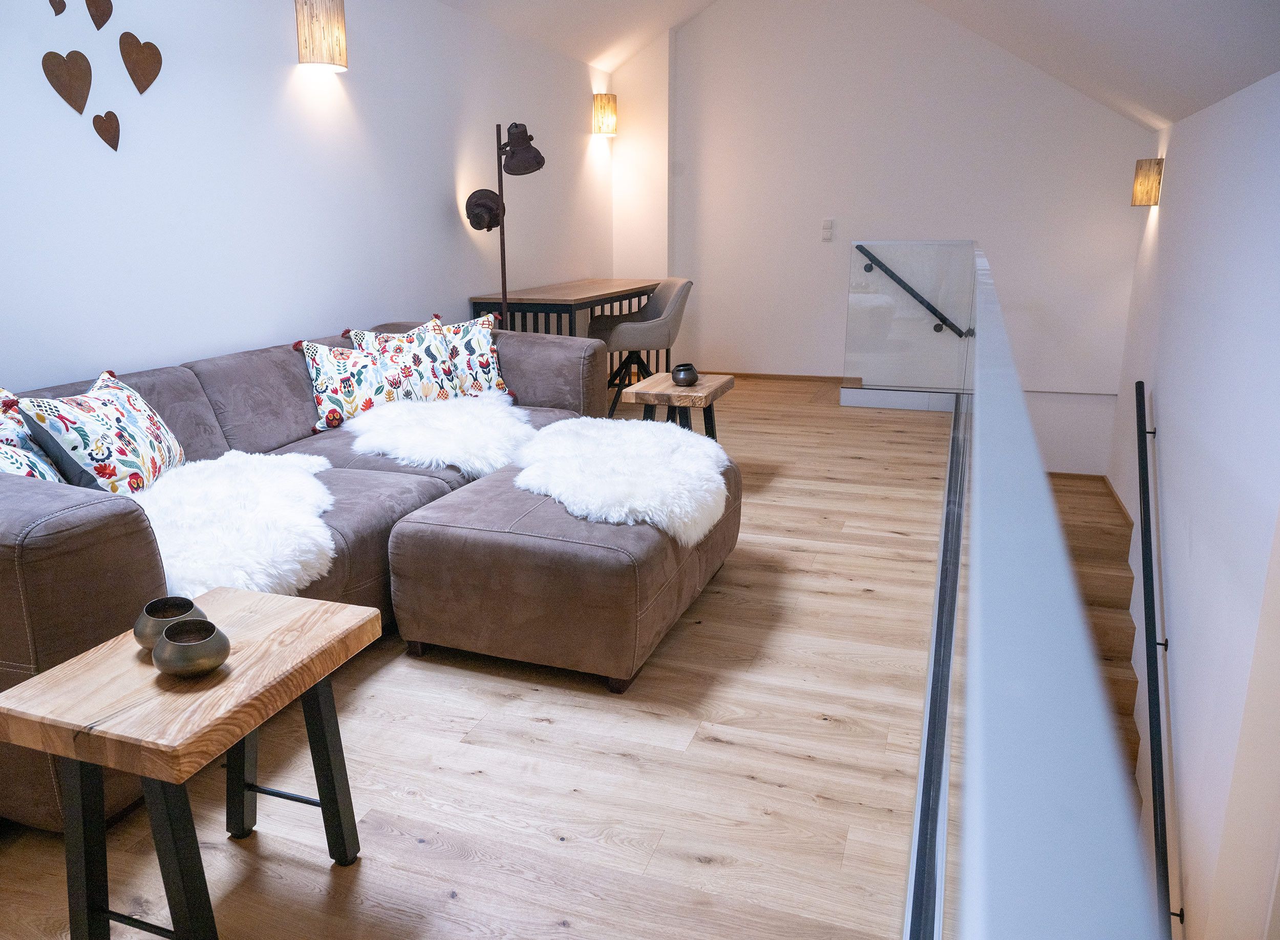 Un salon moderne avec un canapé, une table basse et des coussins décoratifs.