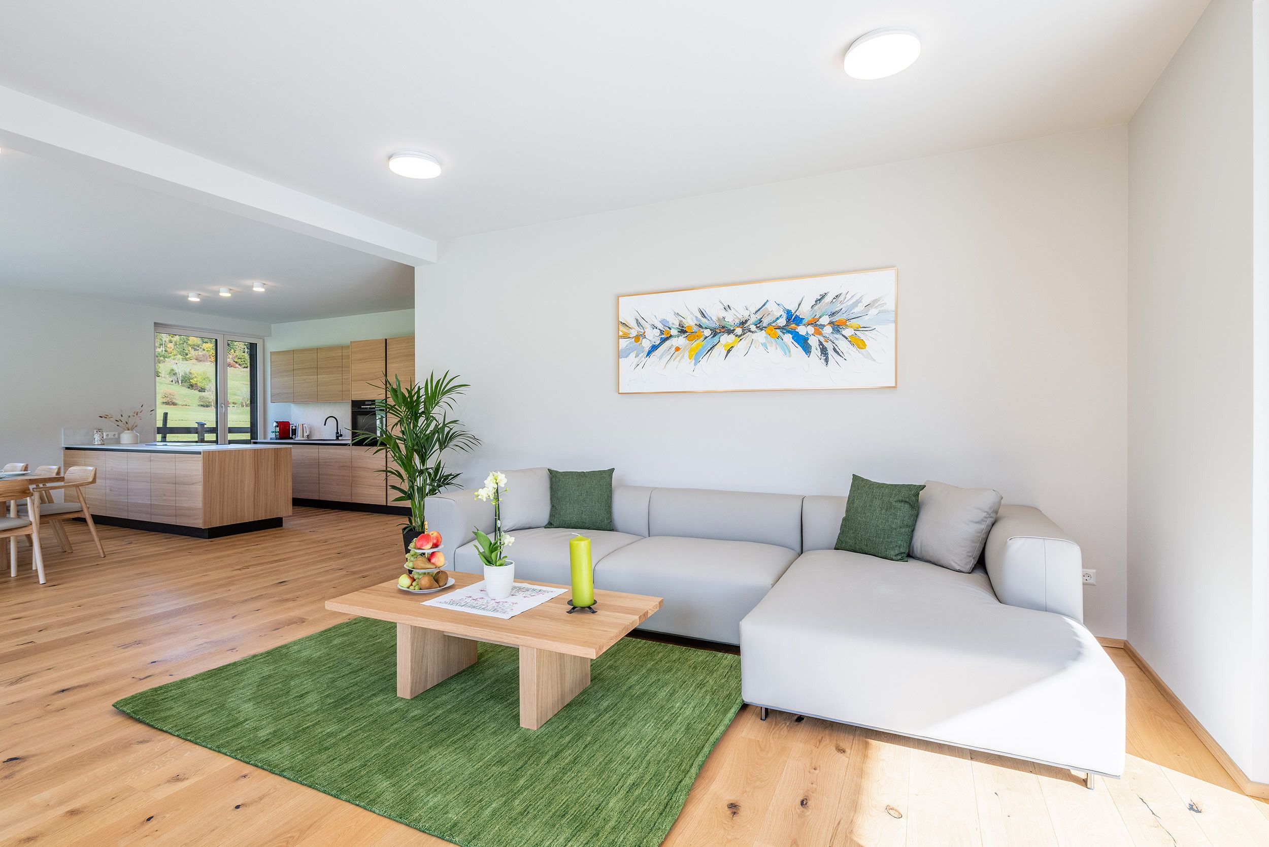A modern living room with a sofa, a coffee table, and a painting on the wall.