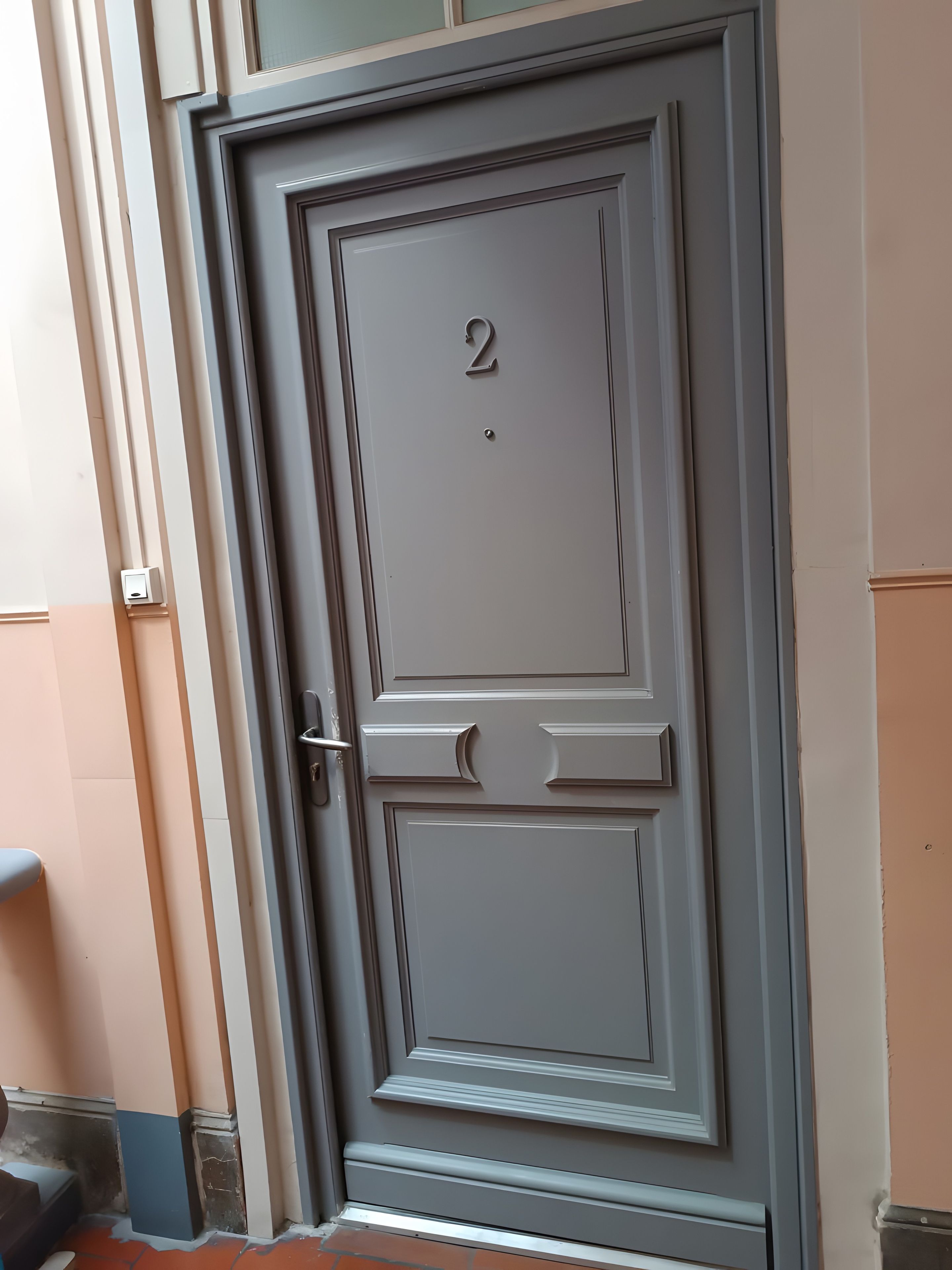 A door with the number 2, a handle, and a small square object above it.