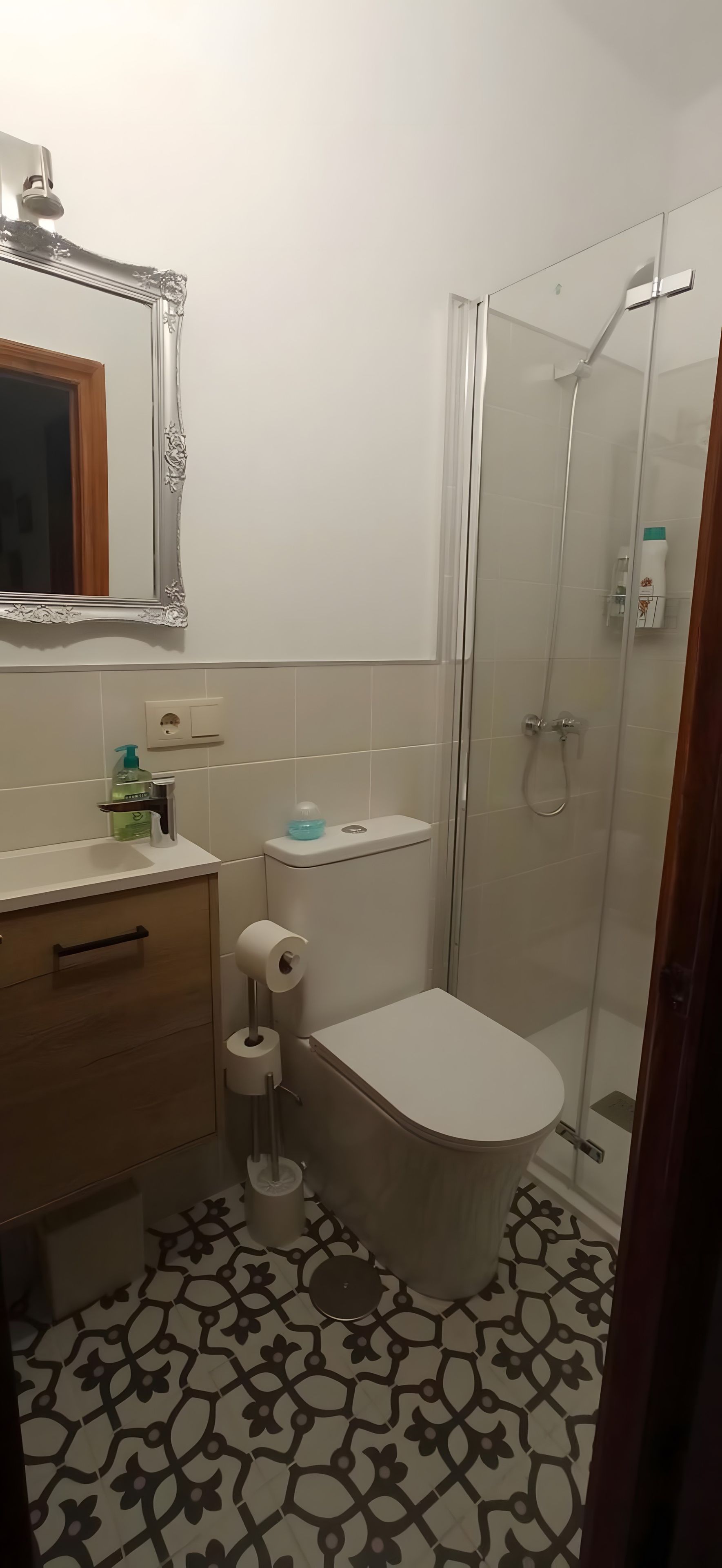 Een badkamer met toilet, wastafel en douche.