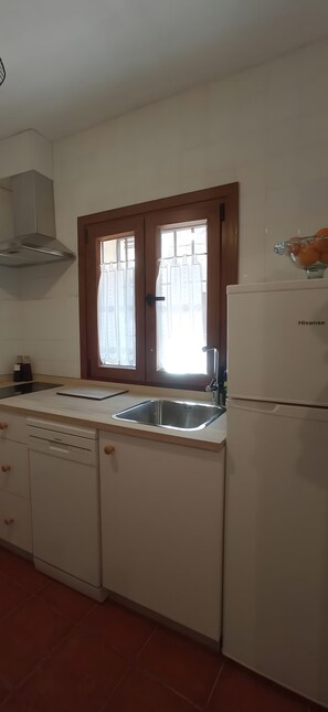 Eine Küche mit einer Edelstahl-Spüle, einem Geschirrspüler und einem Kühlschrank.
