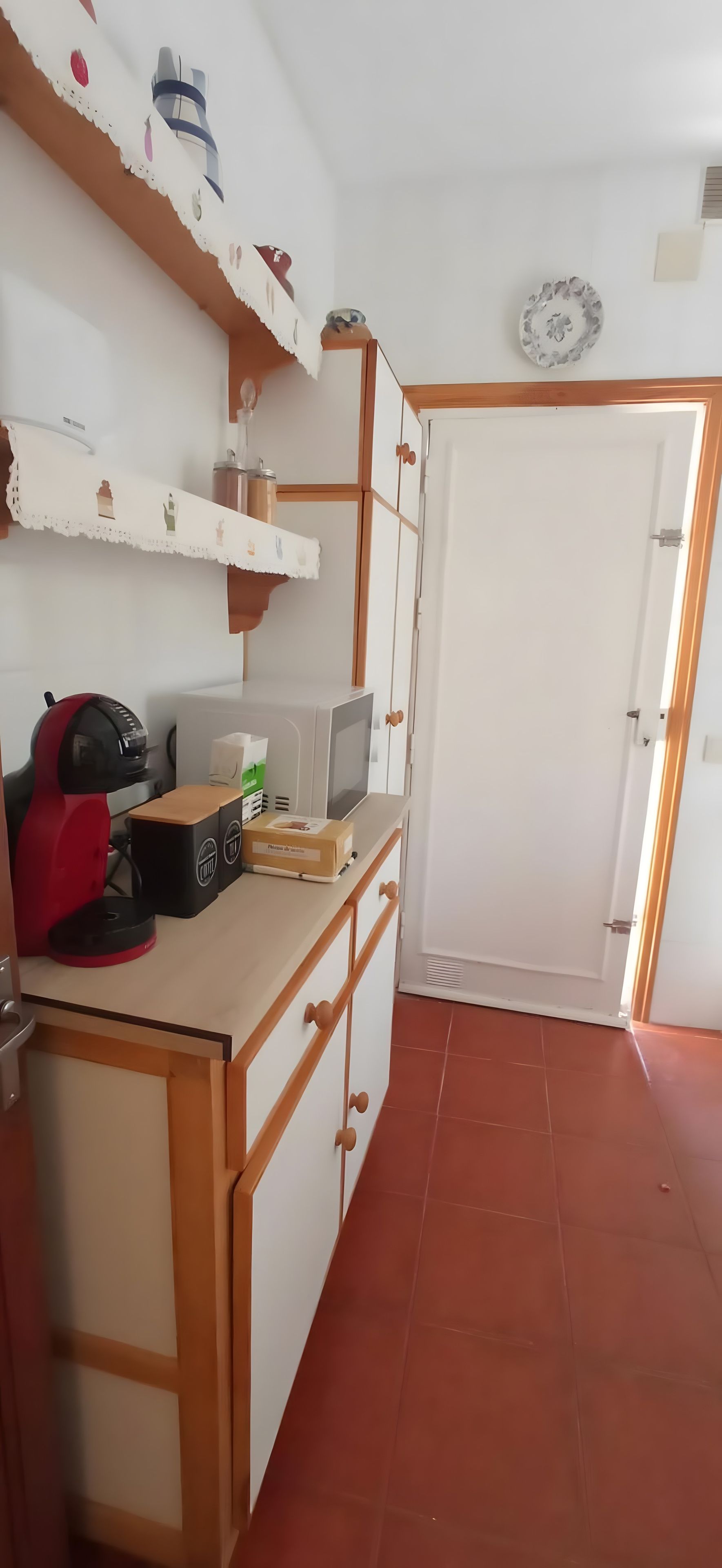 A compact kitchen with a microwave, toaster, and a small refrigerator.