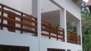 Um edifício de dois andares com varanda, janelas amplas e uma porta.