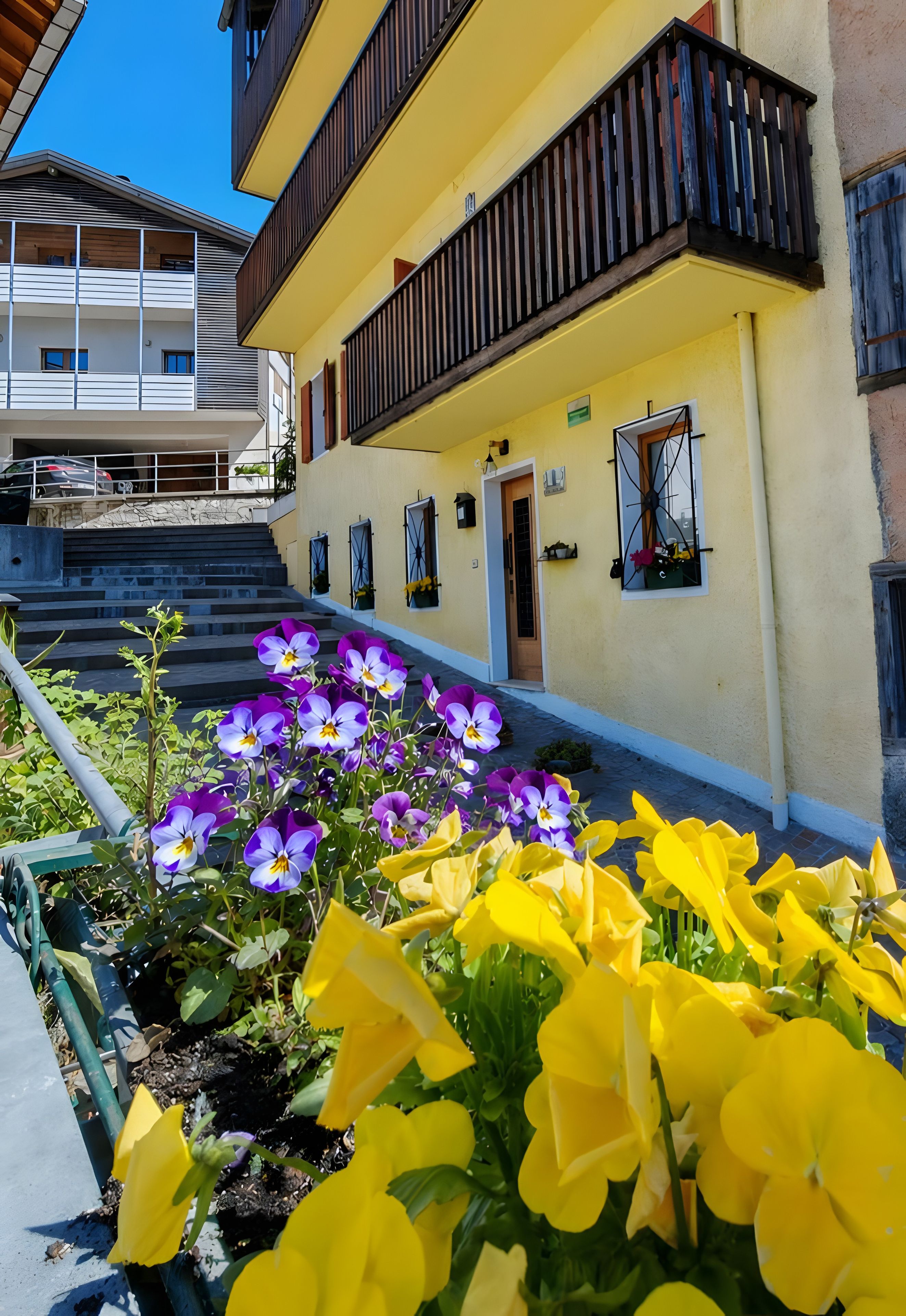 Ein gelbes Gebäude mit Balkon, Tür und Fenstern.