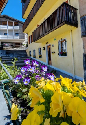 Un bâtiment jaune doté d’un balcon, d’une porte et de fenêtres.