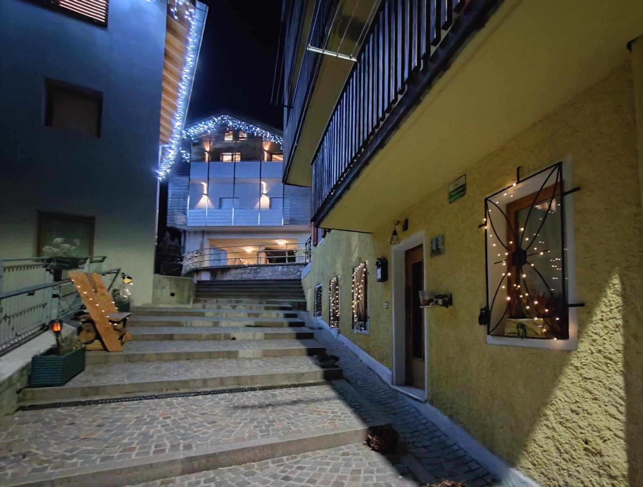 Eine Treppe führt zu einem mehrstöckigen Gebäude, das mit Lichterketten geschmückt ist.
