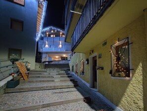 Un escalier menant à un immeuble à plusieurs étages, décoré de guirlandes lumineuses.