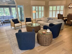 A spacious living room with a sofa, chairs, a coffee table, and a dining area with wicker chairs. - New Listing!  Beautifully Furnished 3 Bedroom in Sea Pines (Hilton Head Island)