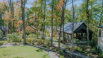 A residential area with multiple houses, a covered outdoor seating area, and a well-maintained lawn.