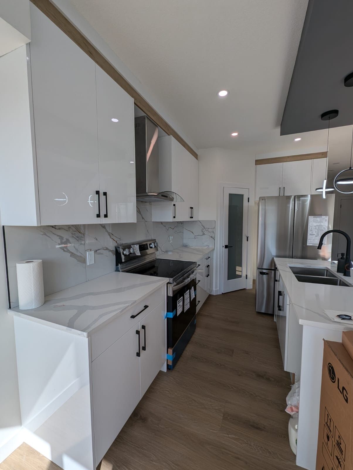 Een moderne keuken met witte kastjes, een roestvrijstalen koelkast en een inbouwoven.