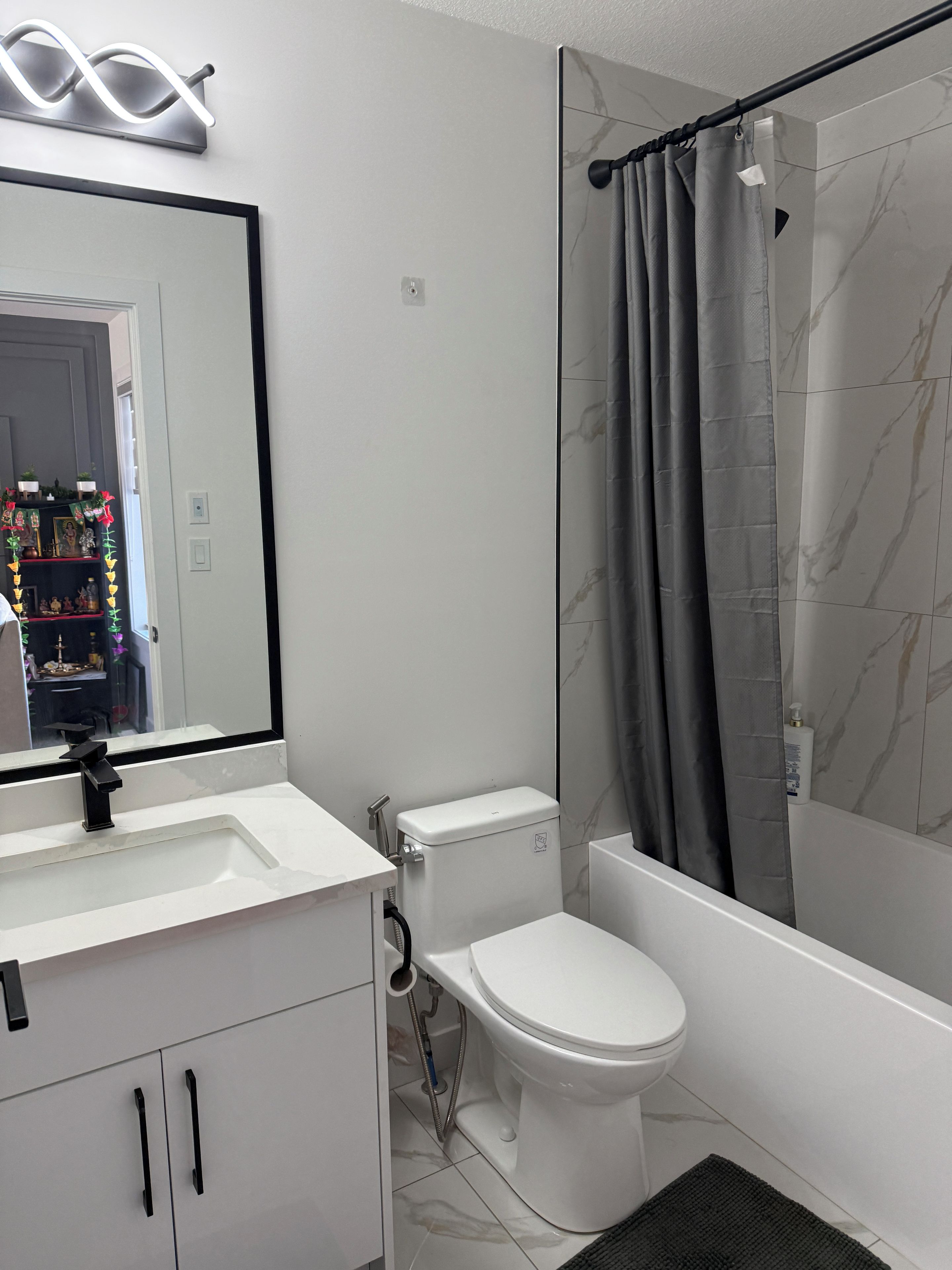 Een badkamer met toilet, wastafel en douchegordijn.