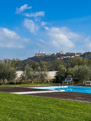 Piscina com vista para um edifício no topo da colina.