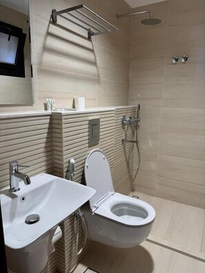 Un baño moderno con ducha, inodoro y lavamanos.
