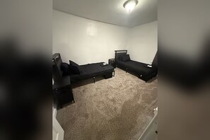 A room with two single beds, a small table, and a carpeted floor. - Spacious 2BR w/ Twin Beds & Full Kitchen, Pittsburgh East End (Pittsburgh)