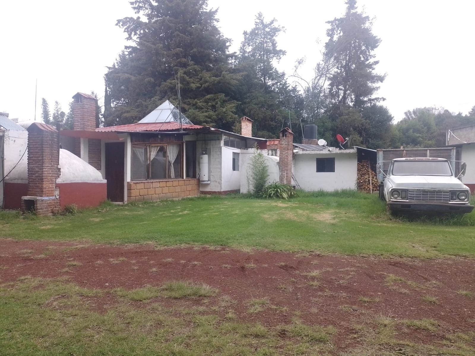 Um imóvel residencial com uma casa térrea, garagem e um carro estacionado.