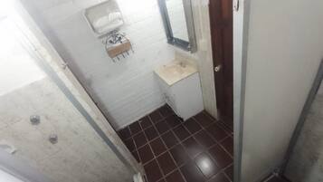Um banheiro pequeno com pia branca, espelho e porta-toalhas.