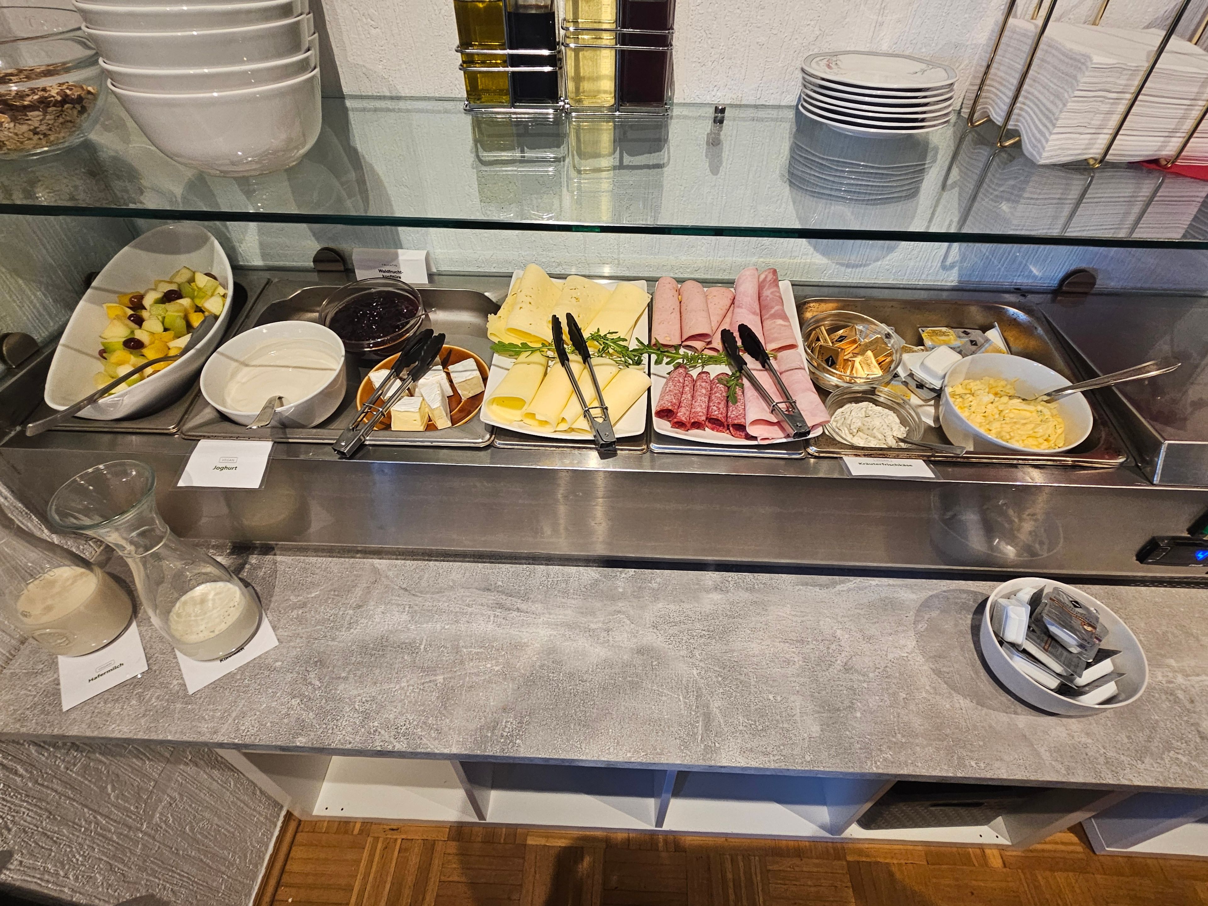 A buffet with various food items and utensils.