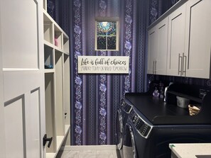 A laundry room with a sign stating 'Life is full of choices Laundry today or mix it tomorrow.' - Deluxe Las Cruces Retreat: Mountain Views, Secure Outdoor Oasis, Modern Comforts (Las Cruces)