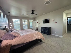 A bedroom with a bed, a ceiling fan, a TV, and a dresser. - Deluxe Las Cruces Retreat: Mountain Views, Secure Outdoor Oasis, Modern Comforts (Las Cruces)
