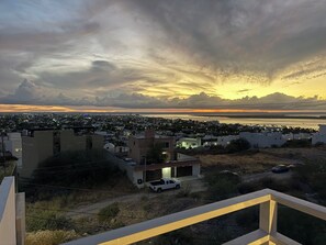 A residential area with houses, a parked truck, and a body of water in the background. - New Listing (La Paz)