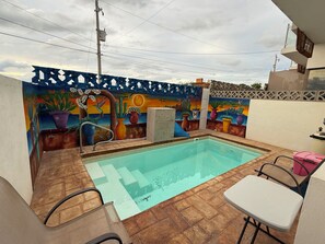 A swimming pool with a tiled deck, surrounded by a decorative wall with murals. - New Listing (La Paz)