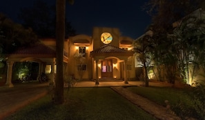 A well-lit residential property with a large circular window, a covered entrance, and a pathway leading to the main door. - New Listing (Playa del Carmen)