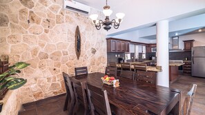 A spacious kitchen with a stone wall, wooden dining table, and modern appliances. - New Listing (Playa del Carmen)