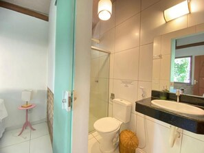 A bathroom with a toilet, sink, and shower area. - Maui Suítes e Chalés (Arraial d'Ajuda)